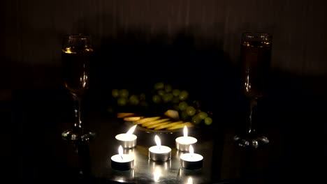 Noche-romántica-con-velas-con-champagne-y-frutas
