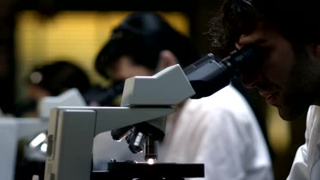 Students-in-a-chemistry-lab-look-through-a-microscope-during-their-experiments