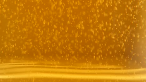 Slow-tilting-on-glass-full-of-beer-bubbles-and-foam-4K-2160p-UltraHD-footage---Golden-full-color-of-fresh-beer-bubbles-4K-3840X2160-UHd-video