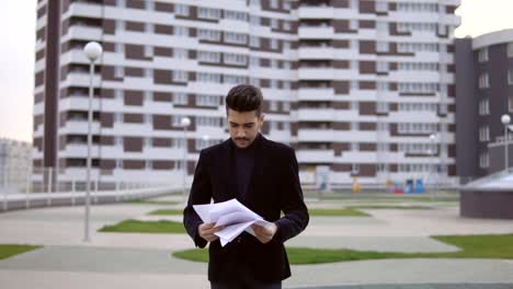 businessman-in-black-suit-walking-and-throw-out-documents-against-business-building-background-outdoor