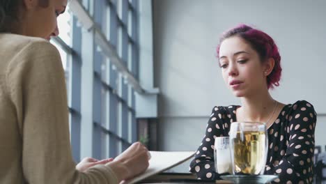 Artist-sketching-female-model-at-cafe