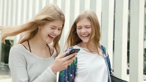 Young-Ladies-Using-a-Phone-in-Town