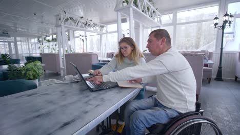 successful-invalid-man-restaurant-owners-on-wheelchair-with-woman-working-on-laptop-computer-for-planning-and-managing-business-and-develop-ideas