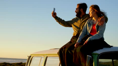 Pareja-tomando-selfie-durante-puesta-del-sol-en-la-playa-de-4k