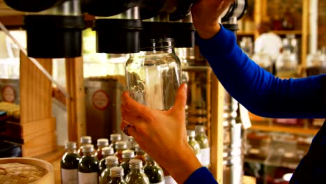 Close-up-of-woman-filling-grains-in-to-jar-from-vending-machine-4k