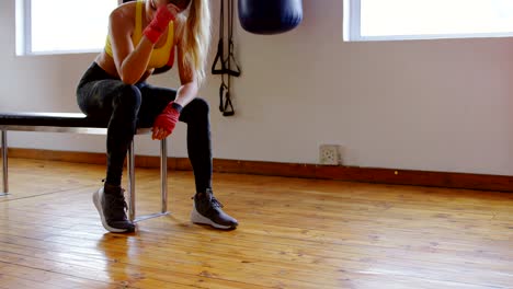 Female-boxer-relaxing-in-fitness-studio-4k