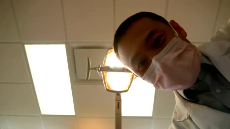 Male-dentist-examining-a-patient-with-tools-4k
