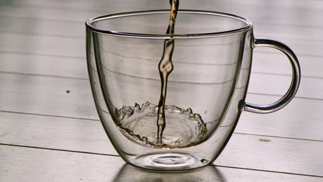 Pouring-hot-tea-into-a-glass-in-slowmotion