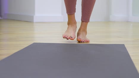 young-woman-feet-unrolling-mat-and-stepping-on-it-in-slow-motion