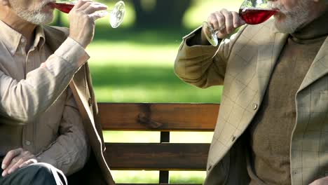 Aged-gentlemen-drinking-wine,-enjoying-alcohol-beverage-taste,-relax-outside