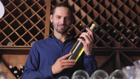 Sonriente-hombre-con-botella-de-vino-de-bodega-en-bodega-restaurante