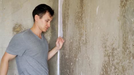 Angry-depressed-man-standing-near-wall-and-knocking-fists