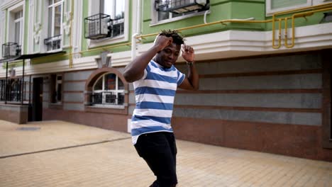 Stylish-african-american-man-dancing-in-city-street