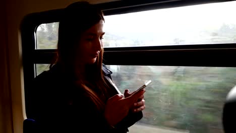 Woman-in-train-using-smart-phone