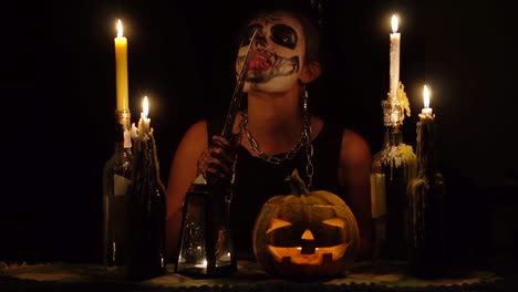 Bruja-de-Halloween-lame-cuchilla-en-cadenas-con-maquillaje-cráneo-magia-calabaza-y-velas