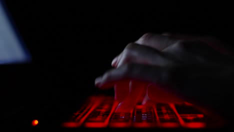 hacker-girl's-hand-typing-on-keyboard-with-red-backlight