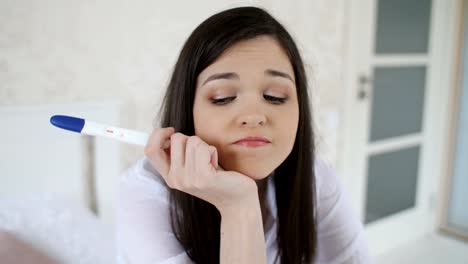 Sad-woman-with-pregnancy-test-at-home