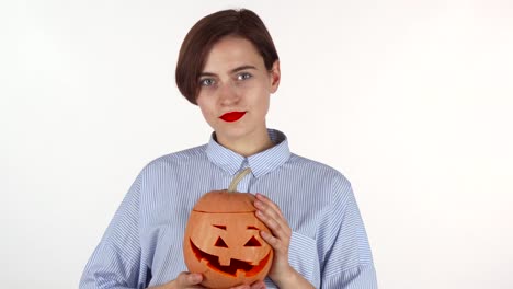 Schöne-Frau-mit-roten-Lippen-lächelnd-glücklich,-hält-Halloween-Kürbis