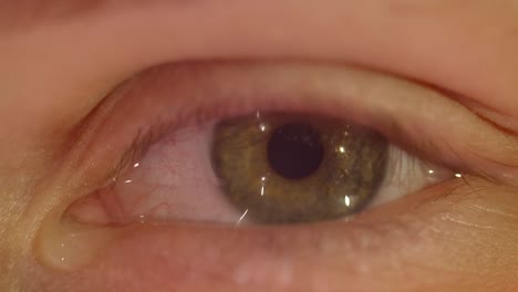 Close-up-shoot-of-peson-with-green-eye-blinks-fastly-with-tears-falling-being-depressed-and-sad-watching-into-camera.