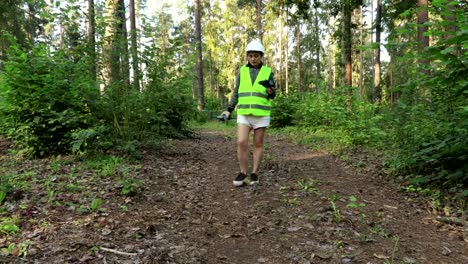 Arbeiterin-startet-Waldinspektion-mit-Drohne-auf-Waldweg