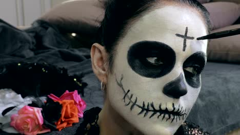 Mujer-aplicar-Día-de-los-Muertos-maquillaje-para-la-fiesta-de-Halloween