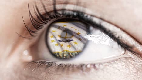 Woman-green-eye-in-close-up-with-the-flag-of-Rhode-Island-state-in-iris,-united-states-of-america-with-wind-motion.-video-concept