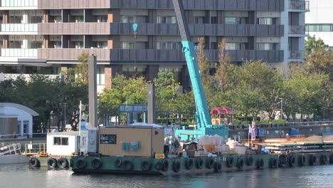 Ein-hoher-blauer-Kran-an-der-Seite-des-Flusses-in-Tokio