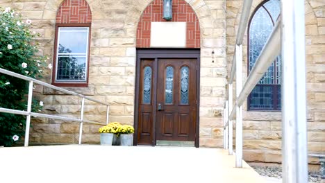 Cacerolas-de-la-cámara-a-través-de-la-entrada-de-una-iglesia-o-una-capilla-exterior-en-verano