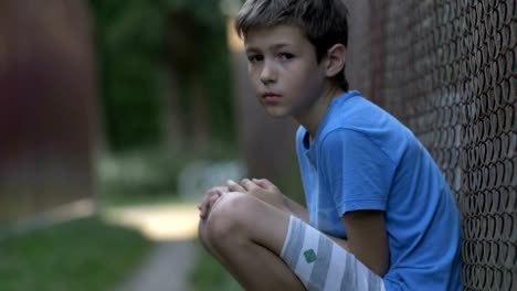 Sad-upset-abused-teenager-boy-sitting-alone,-lonely-serious-offended-boy,-pain-on-face,-close-up