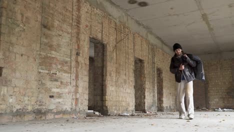 Vagabundo-enfermo-camina-con-bolsa-de-basura-en-edificio-abandonado