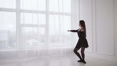 a-young-woman-resembling-a-gymnast-stands-in-a-ballet-position