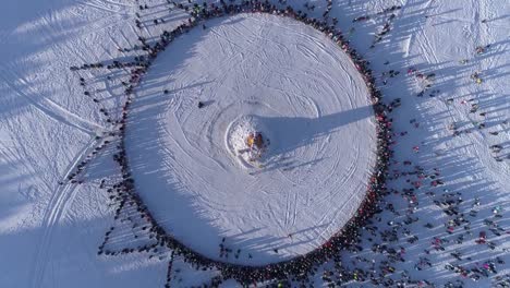 Circle-of-people-which-watch-burning-of-dummy-during-celebration-of-Russian-traditional-holiday-Maslenitsa.-Footage.-Aerial-view