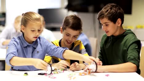 Grupo-de-niños-aprendiendo-a-crear-robots-en-lección-de-escuela-de-robótica