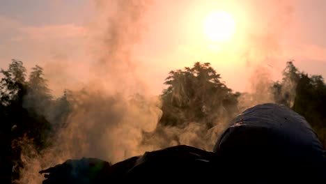 Movimiento-lento-del-fuego-ardiente-bolsa-de-basura-en-fondo-oscuro-amanecer.-Blanco-humo-flotando-a-contaminación-del-aire-y-de-ambientes-peligrosos.-La-basura-es-basura-de-la-comunidad.-Hacer-efecto-invernadero-de-la-tierra.