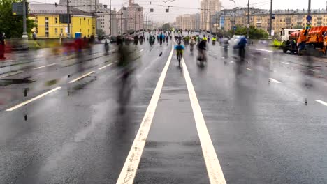 parade-of-bicyclists,-bike-riders--despite-the-bad-weather,-time-lapse