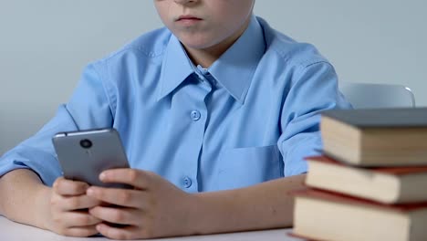 Cute-school-pupil-surfing-internet-at-desk,-gadget-addiction,-playing-games