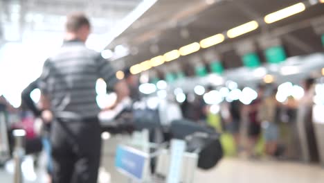 Unscharfe-Aufnahmen-der-Passagiere-zu-Fuß-zum-Check-in-Schalter-am-Flughafen-terminal.-4K-Video-mit-defokussierten-Wirkung.