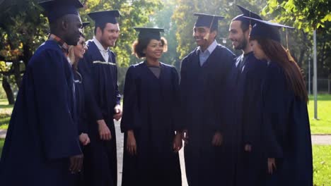 happy-students-in-mortar-boards-with-hands-on-top