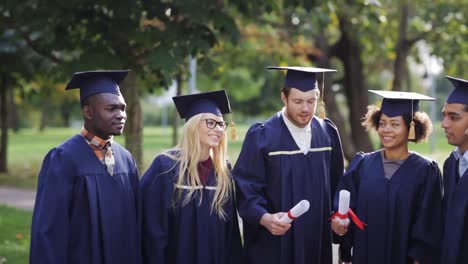 glückliche-Schüler-in-Mörtel-Boards-mit-Diplomen