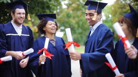 glückliche-Schüler-in-Mörtel-Boards-mit-Diplomen