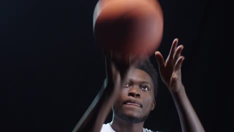 Basketball-Spieler-Schießen-Ball-auf-schwarzem-Hintergrund