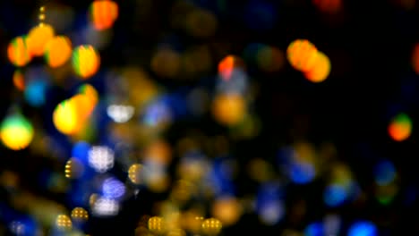 Defocused-shimmering-multicolored-glitter-confetti,-black-background.-Holiday-abstract-festive-bokeh-light-spots.