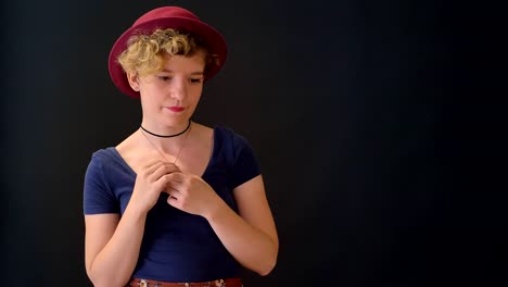 Occupied-young-woman-with-curly-hair-holding-hands-together-and-standing-isolated-on-black-background