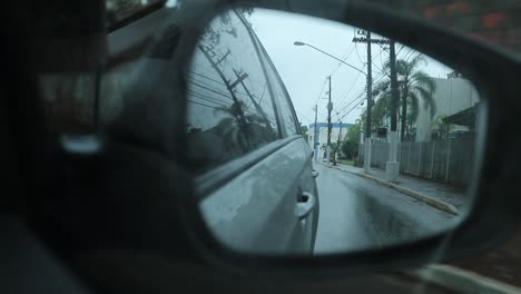 Espejo-de-retrovisor-de-lado-de-coche-durante-el-día-de-lluvia