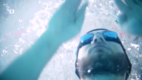 Disabled-man-swims-in-a-swimming-pool.-Underwater-shot.