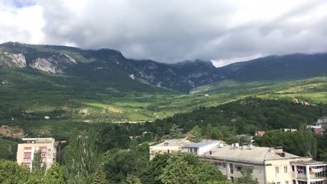 Zeitrafferaufnahmen,-Crimea-Villiage-Gursuf-vor-dem-Regen-auf-dem-Hintergrund-der-Berge-und-Wolken-schnell-über-den-Himmel-bewegen.-FullHD