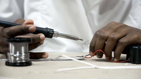 Hands-soldering-wires-at-work