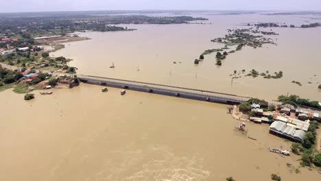 drone-:-flying-over-a-concrete-bridge-running-across-the-flooded-river-in-rural-area