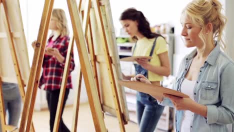 students-with-easels-painting-at-art-school