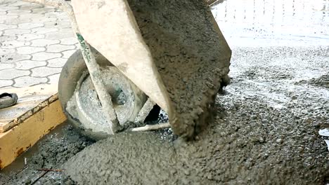 Bauarbeiter-drücken-Schubkarre-mit-Flüssigkeit-Beton-auf-der-Baustelle